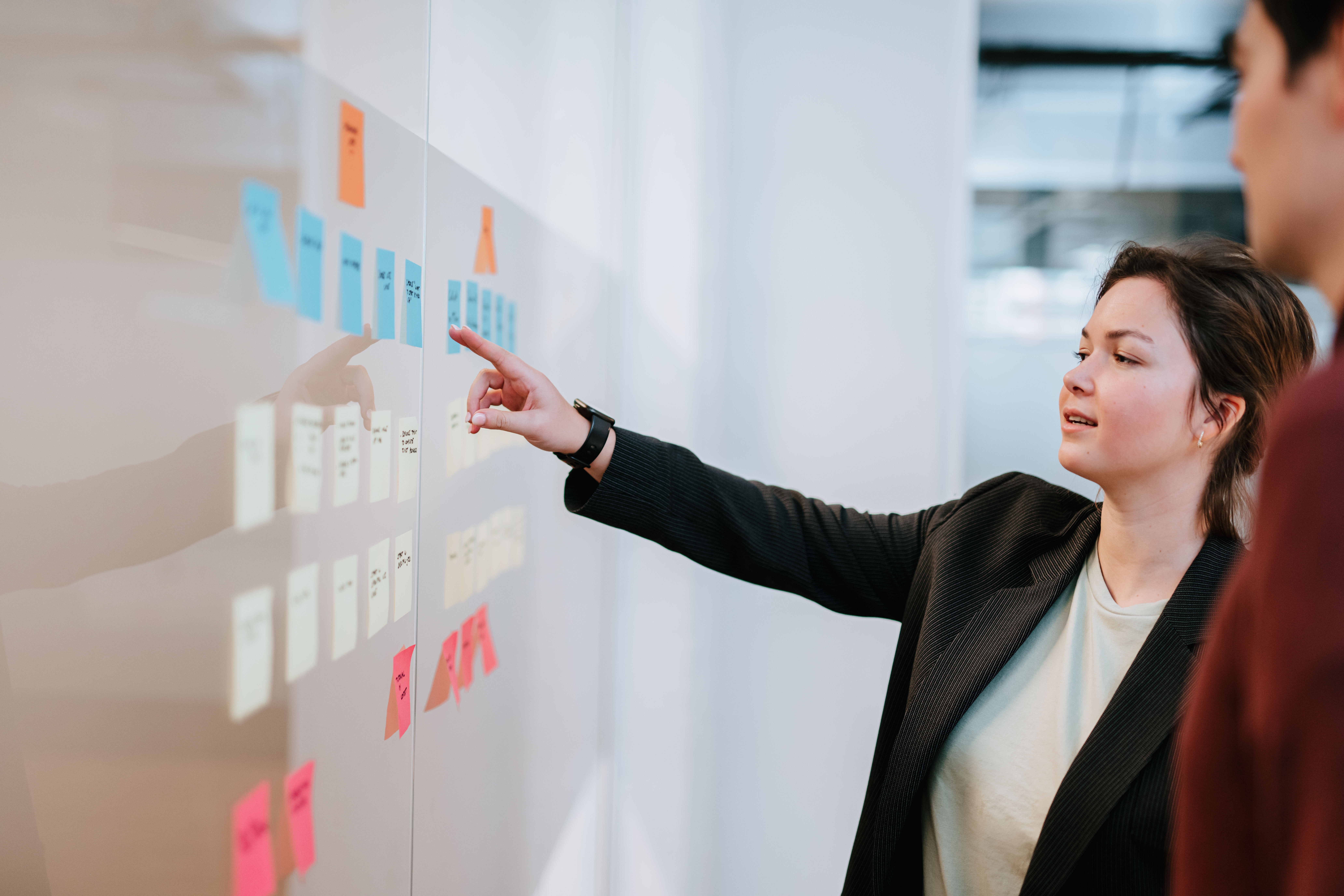 A person pointing at the post-its at the wall