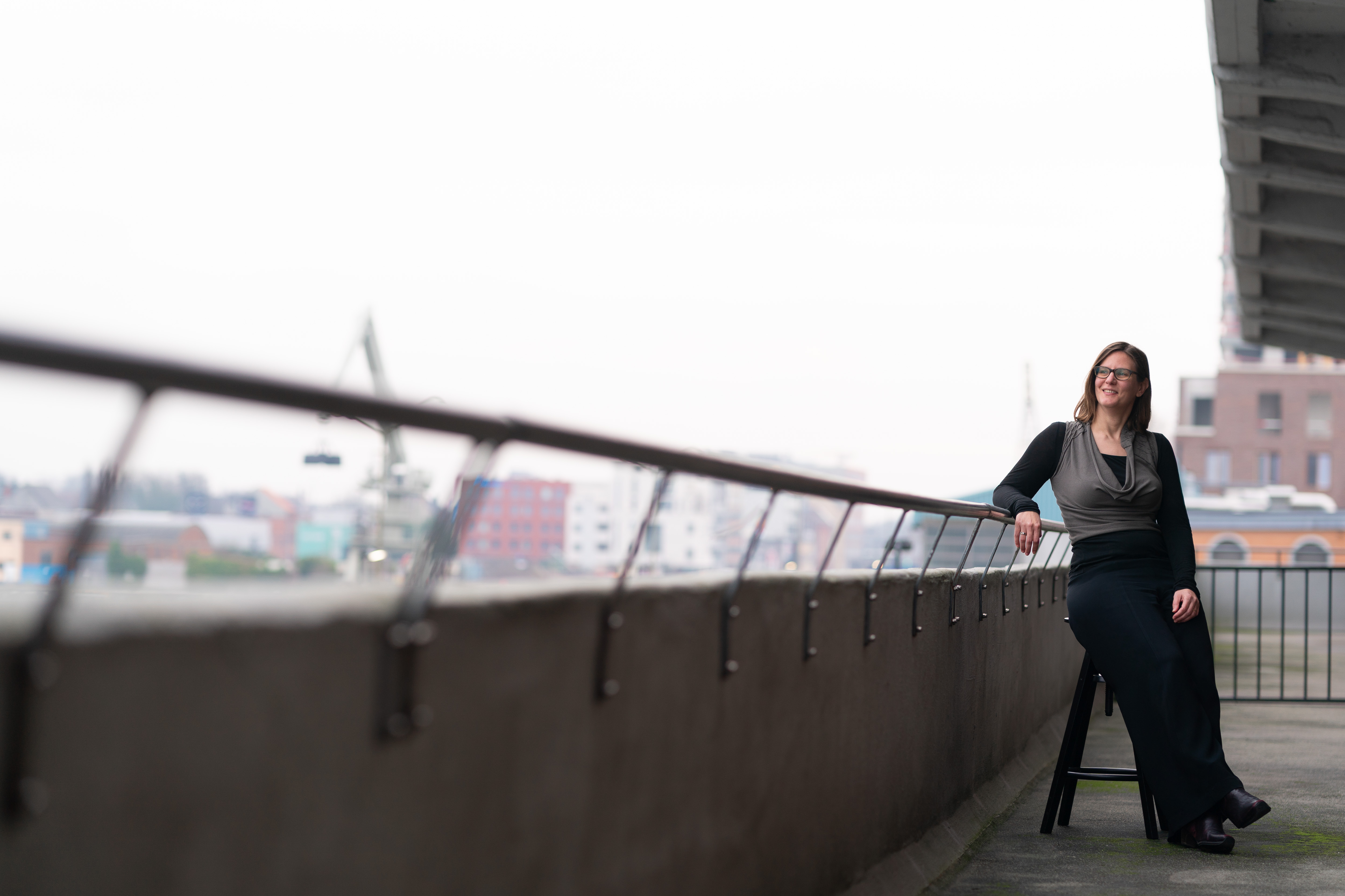 Isabel Donvil, Managing Director at The Reference standing on the balcony of the Ghent office