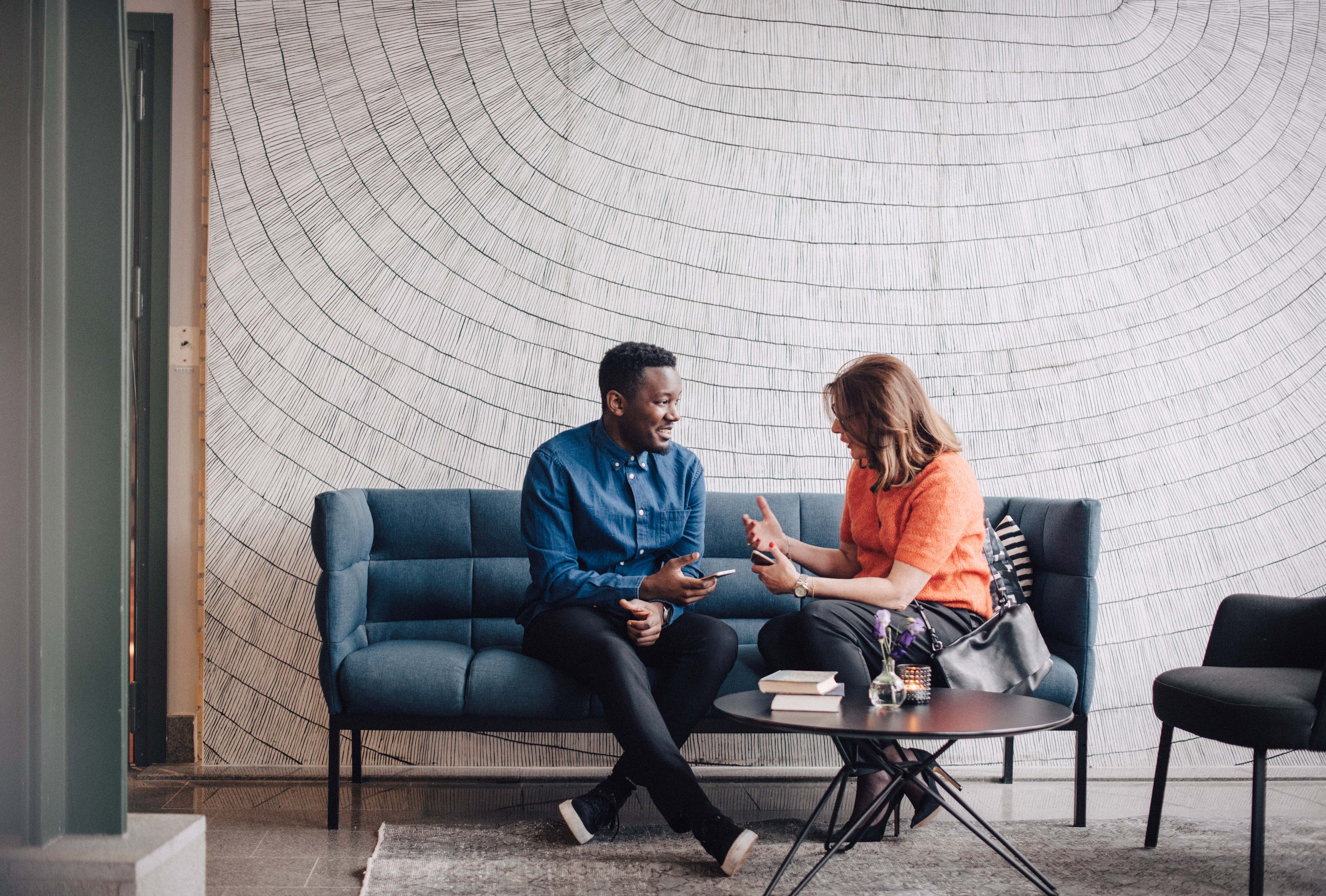 People conversing on sofa