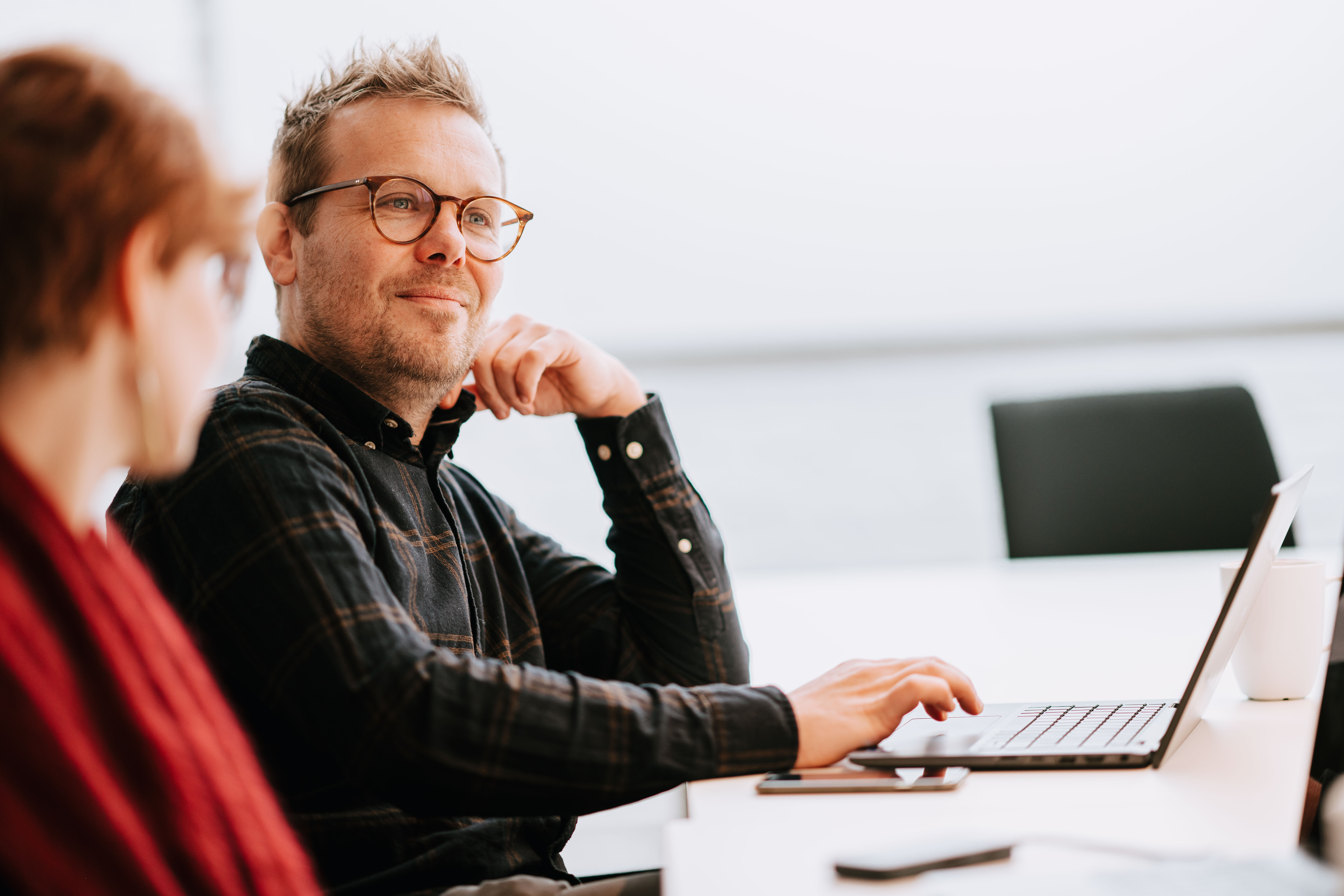 Person behind their laptop looking across the room