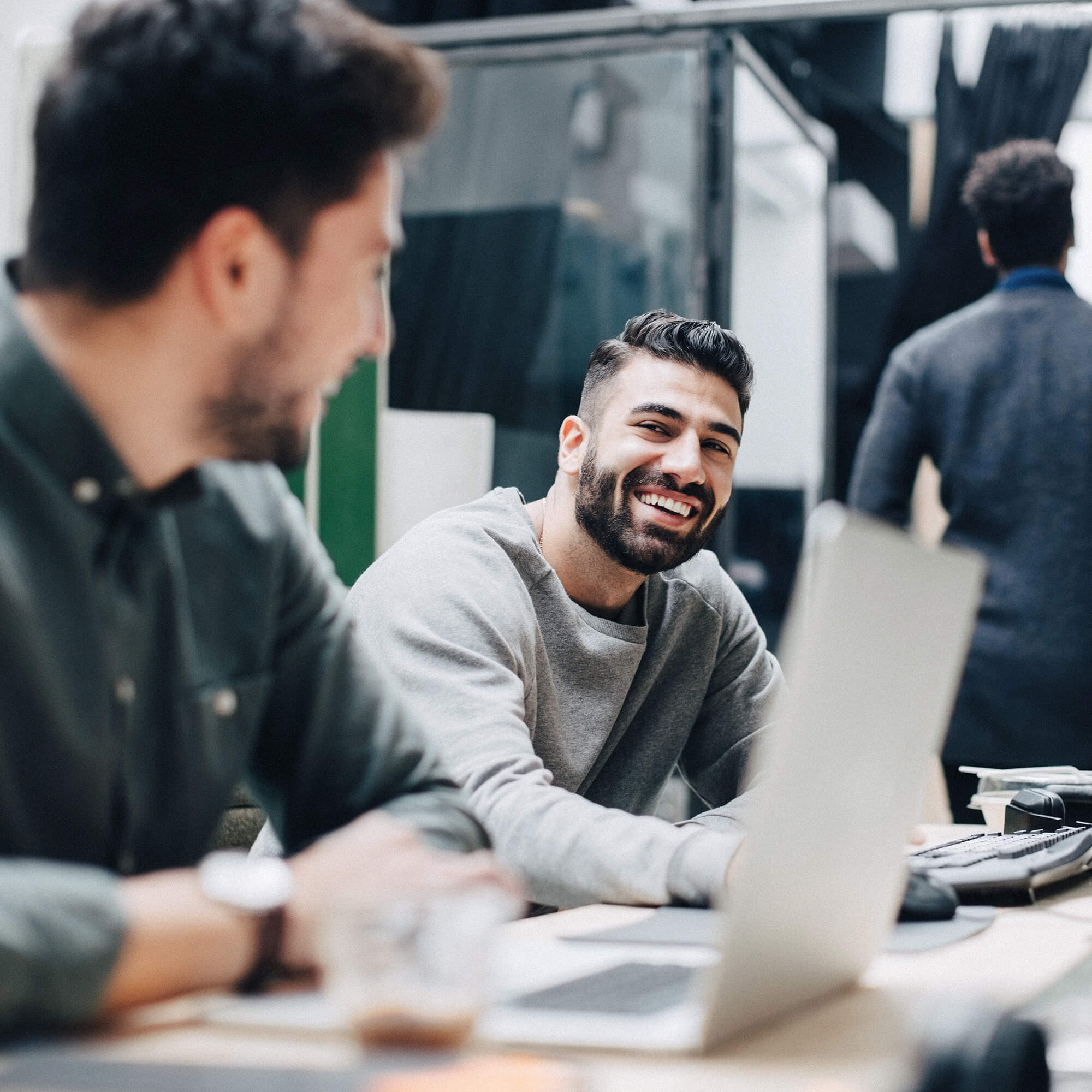 Colleagues chatting behind laptop