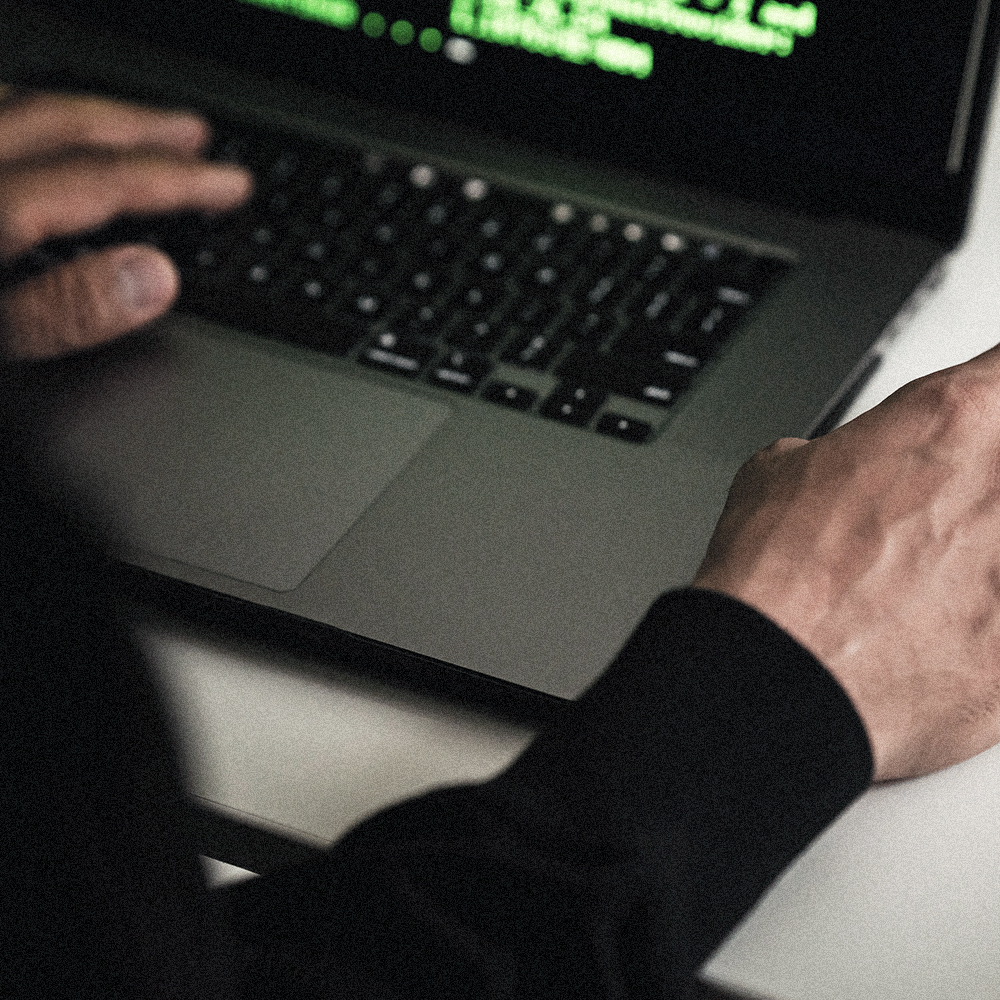 Person coding behind computer