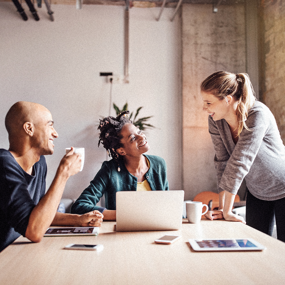 Three people having a casual meeting with some coffee