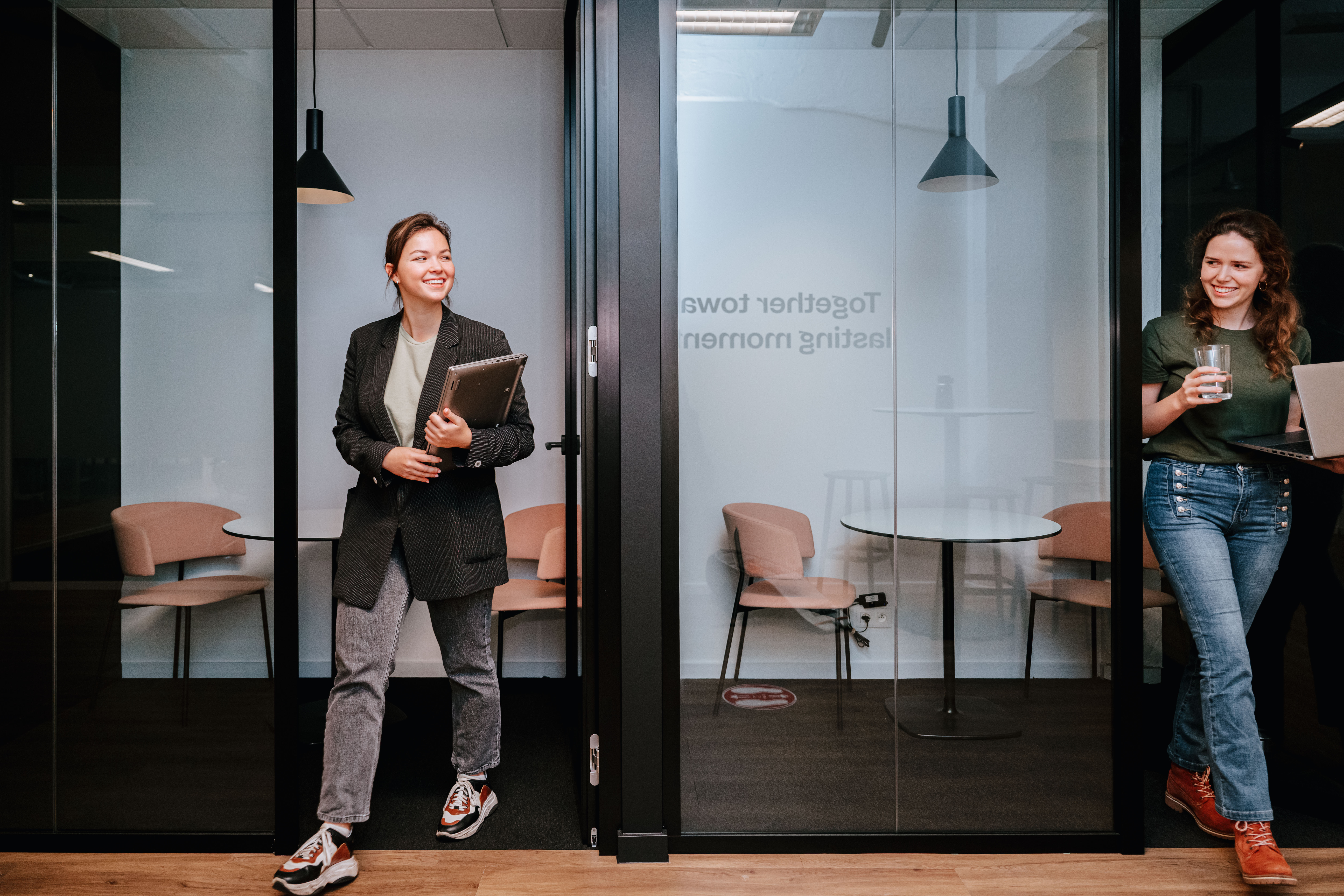 Two people leaving the silent booth smiling 