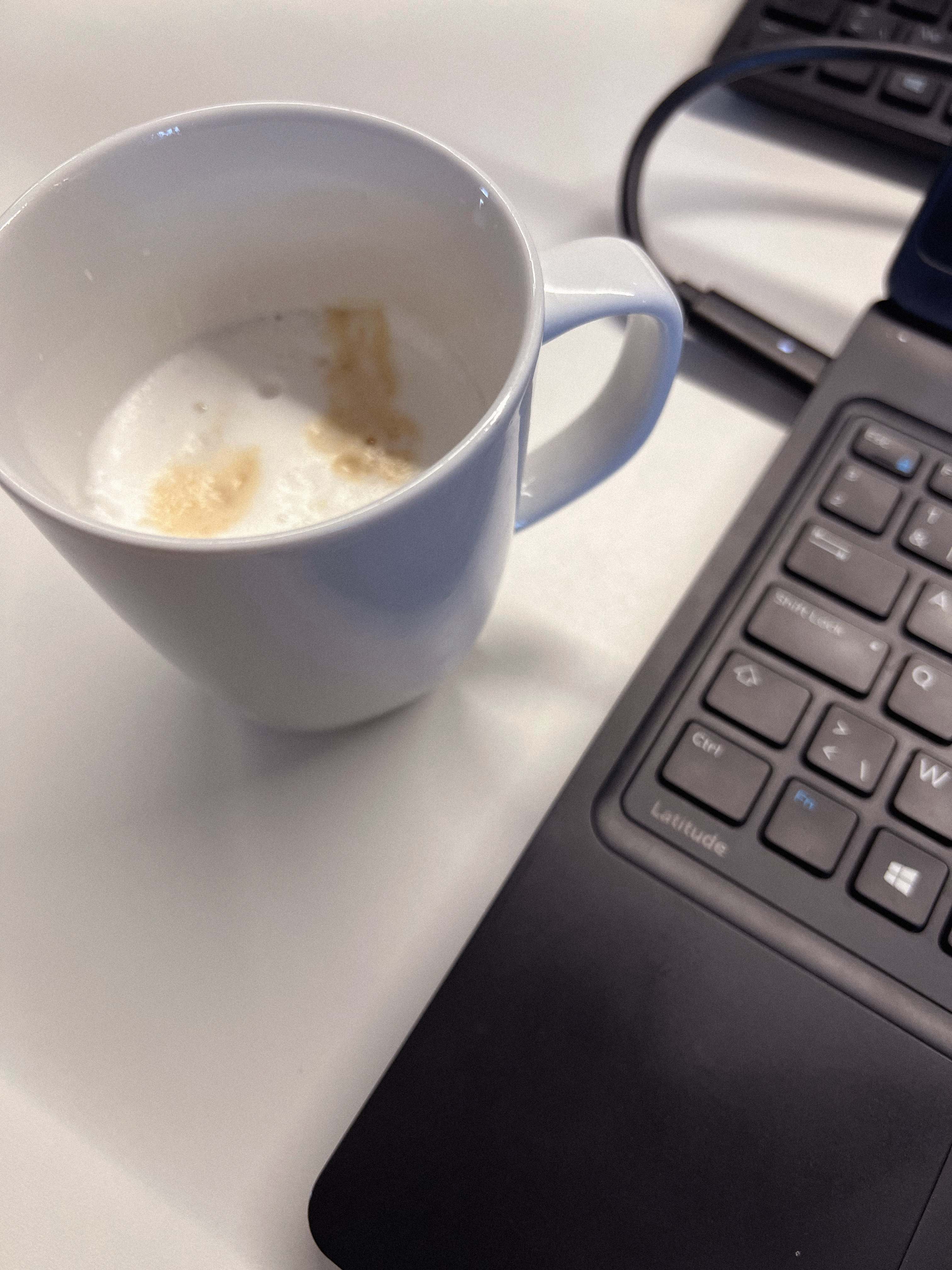 Coffee cup next to laptop