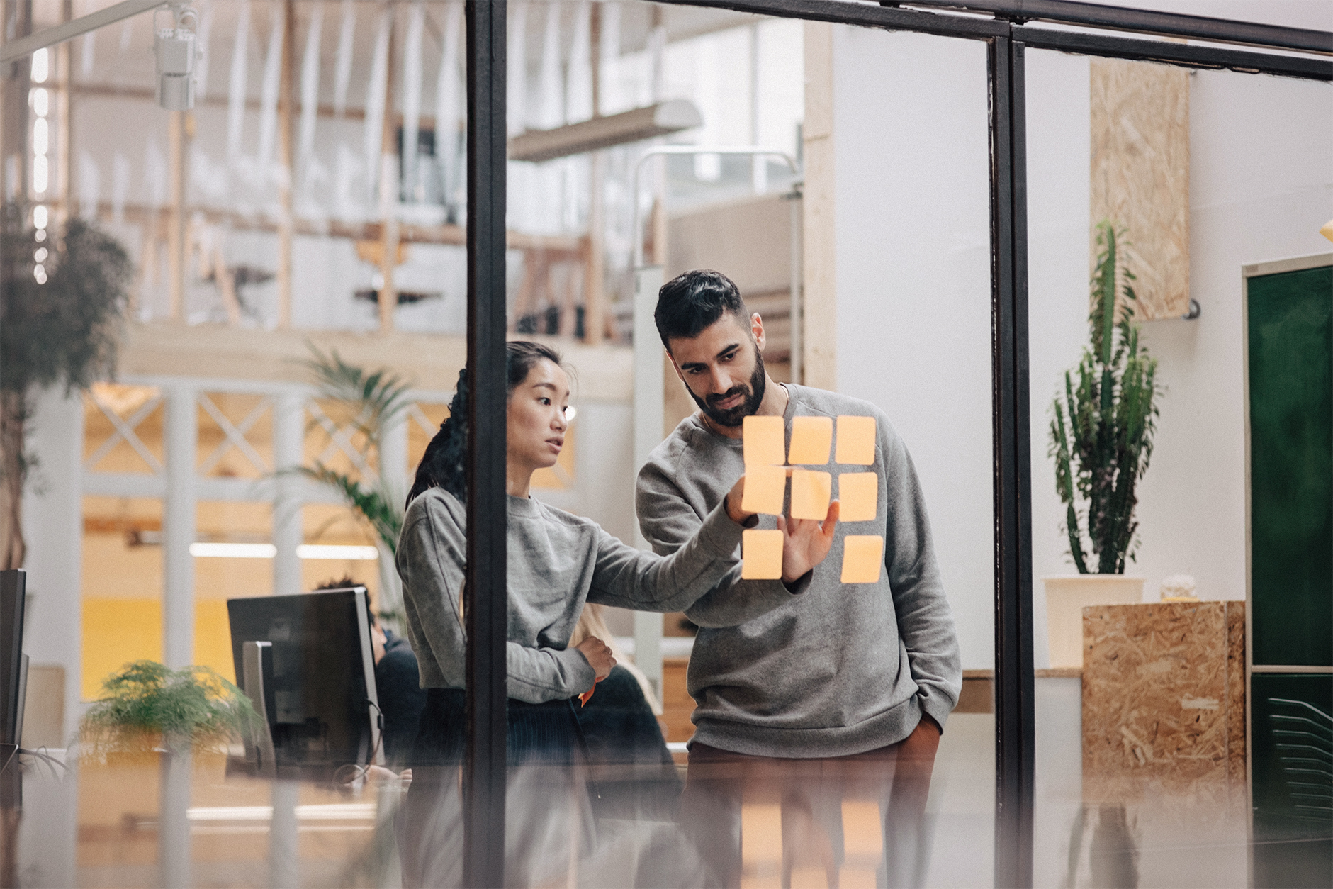 Employees at work putting post-its on a window