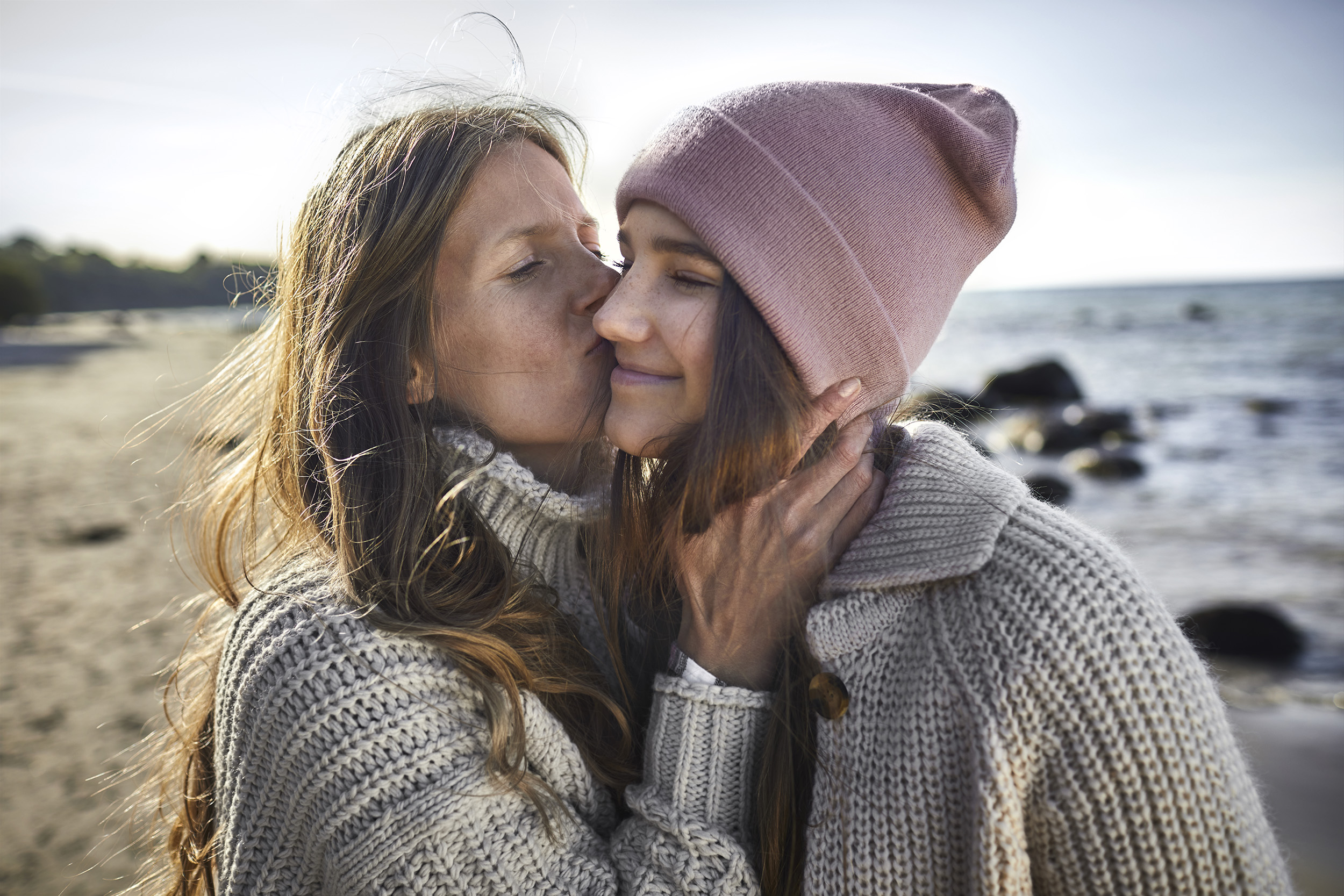 DELA mother kissing her daughter on the cheek 